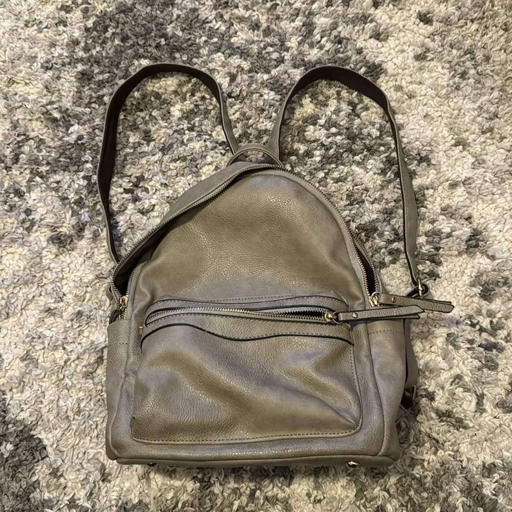 Gray backpack with multiple pockets and zippers from Versona